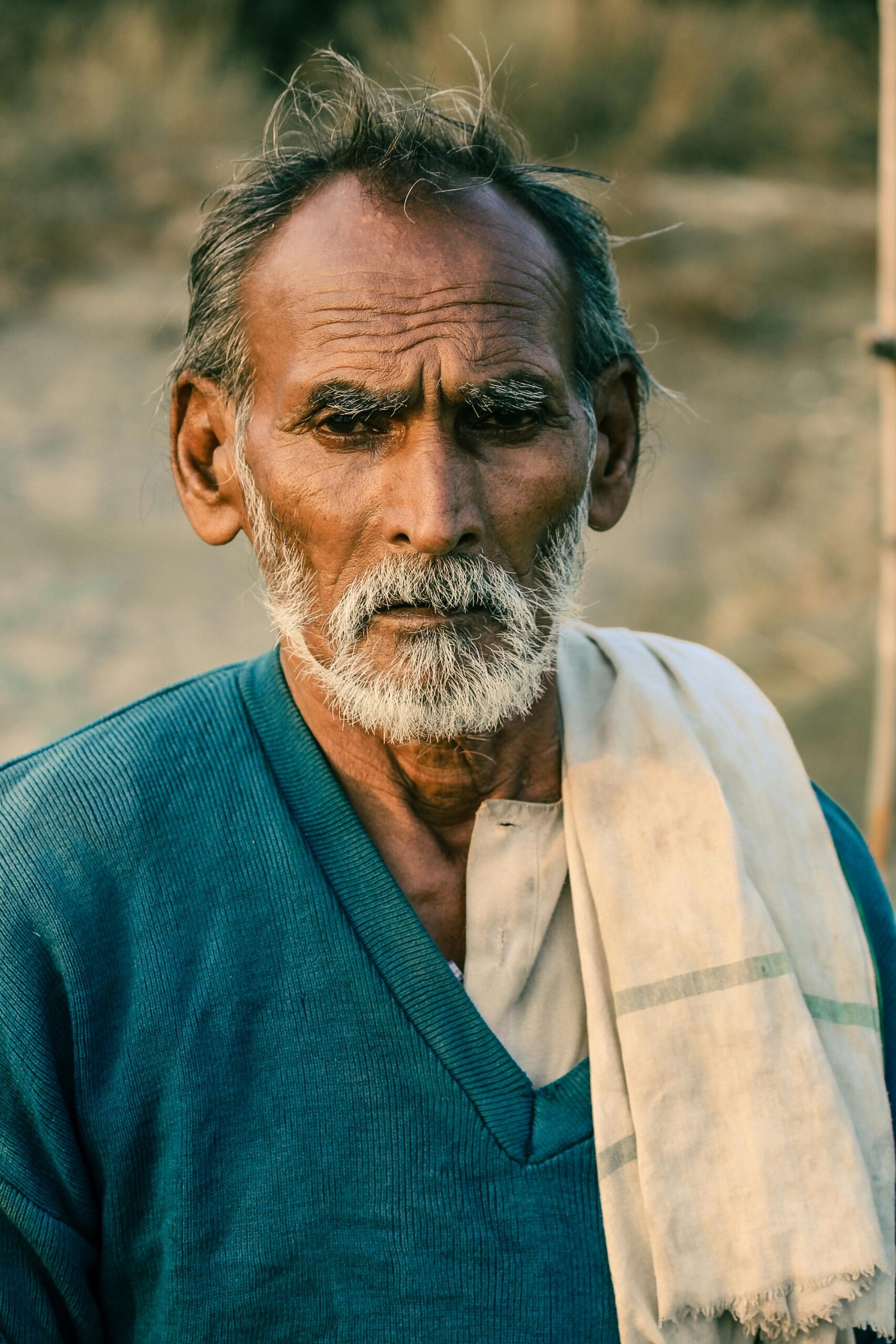Portrait of an elderly man with a beard, wearing traditional clothing in Bhagwantnagar, India.